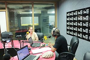 Südwind Mitarbeiterin in einem Radiostudio in Ecuador. Ein Angestellter des Radiosenders interviewt sie