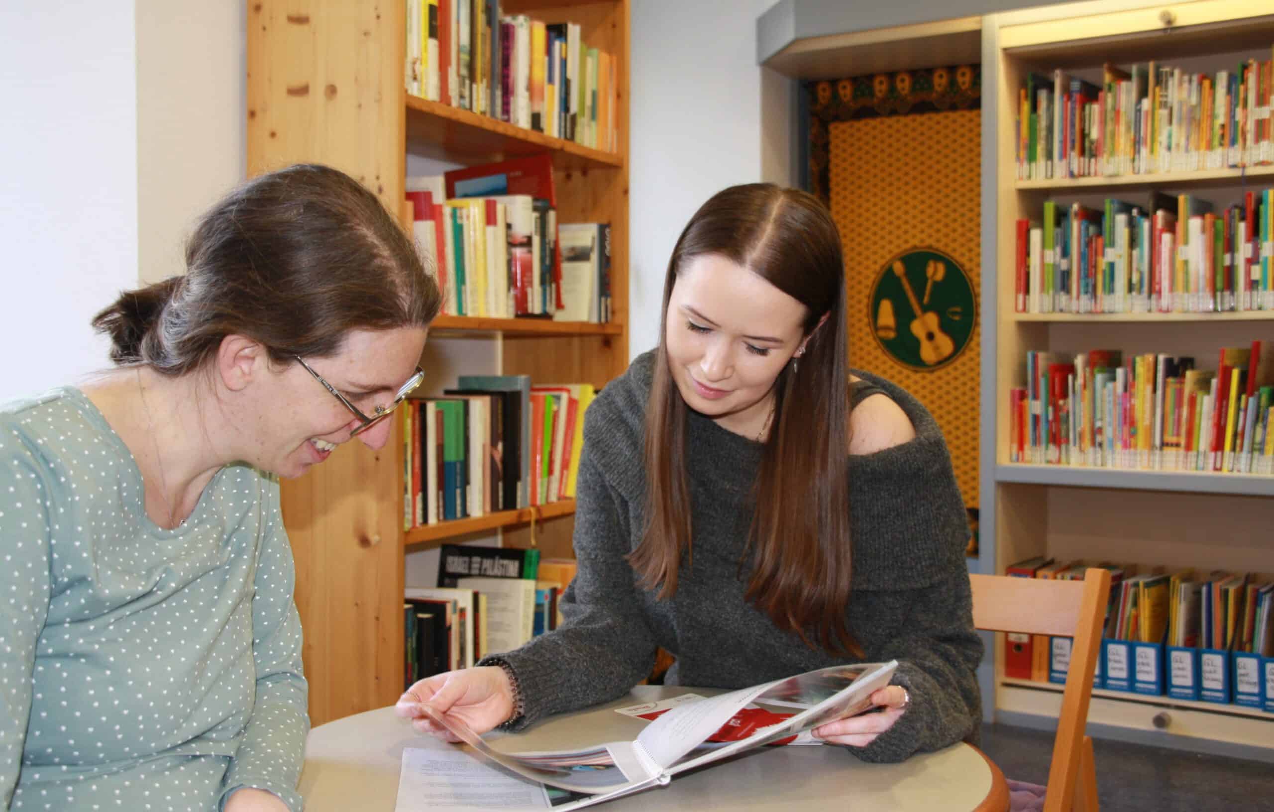 Die beiden Südwind-Mitarbeiterinnen Sonja Jochum und Vanessa Kumer blättern in der Bibliothek in Magazinen